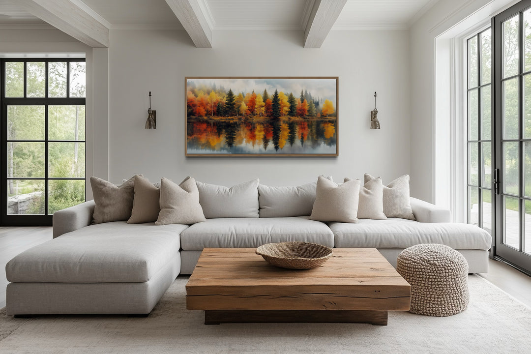 Watercolor fall forest canvas print above a sofa in a rustic, modern living room.