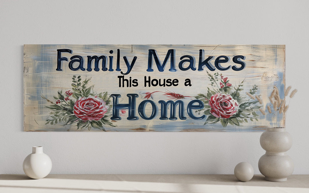 Rustic wooden sign with floral accents reading "Family Makes This House a Home" on a neutral wall.