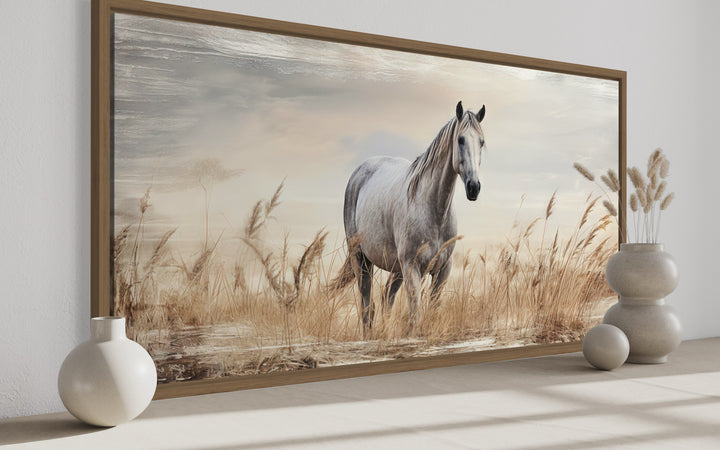 Framed canvas wall art of a white horse standing in a golden wheat field with a rustic finish.