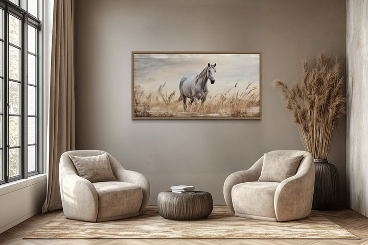 Farmhouse framed canvas wall art featuring a white horse in a golden wheat field above two chairs.