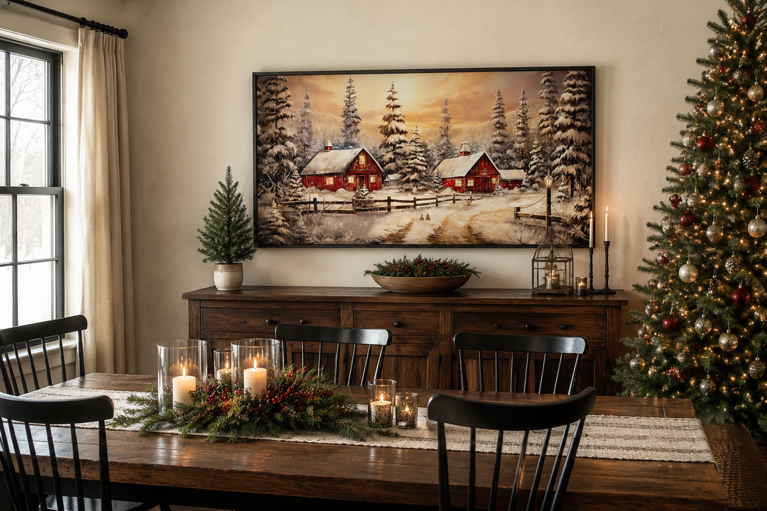 Framed canvas art of a snowy red barn scene hanging above a wooden sideboard in a dining room.