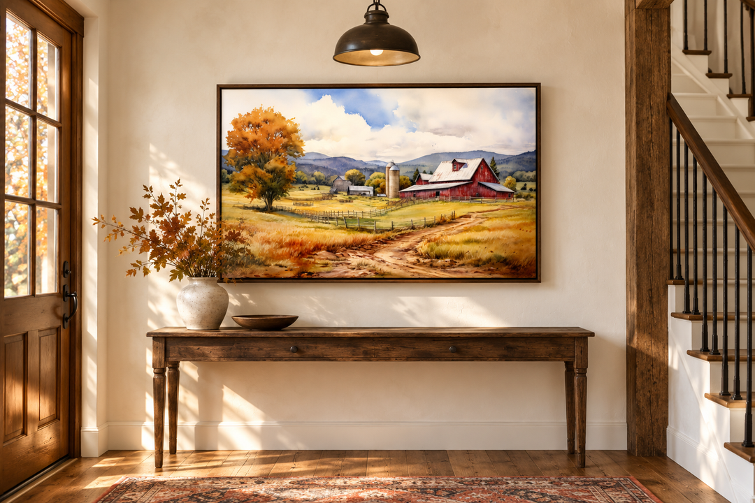 Framed canvas wall art of a red barn in a golden field under a cloudy sky in a rustic entryway.