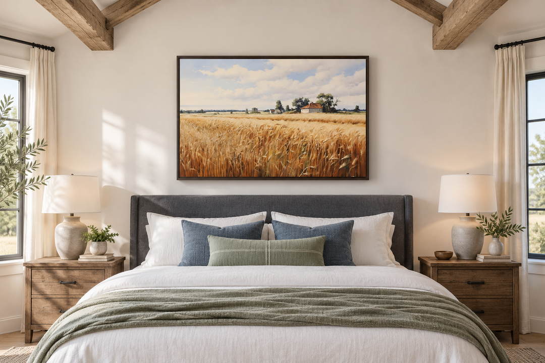 Rustic wheat field landscape framed canvas wall art hanging above a bed in a farmhouse bedroom.