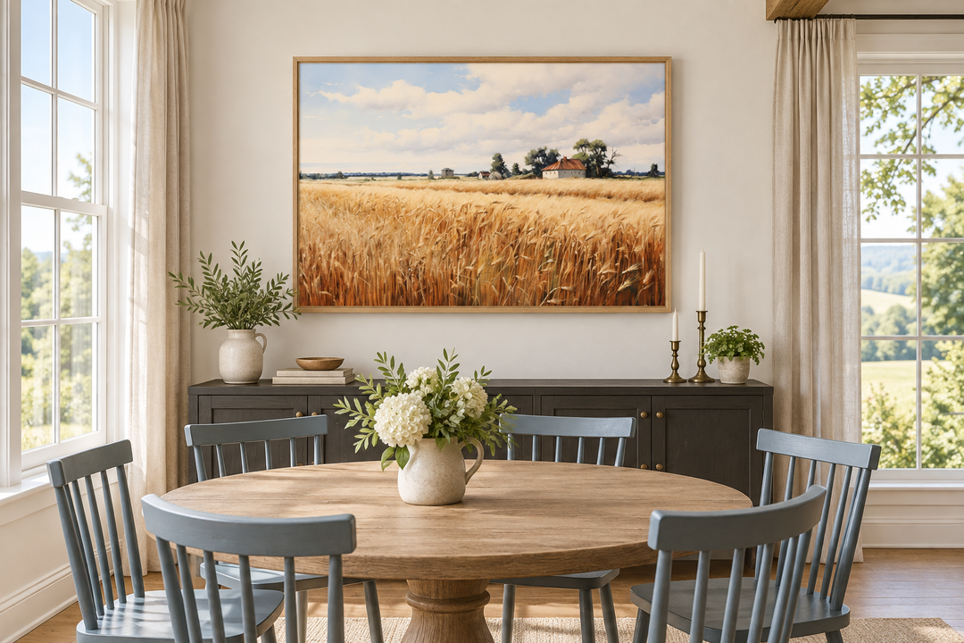 Rustic wheat field landscape framed canvas wall art hanging above a sideboard in a dining room.