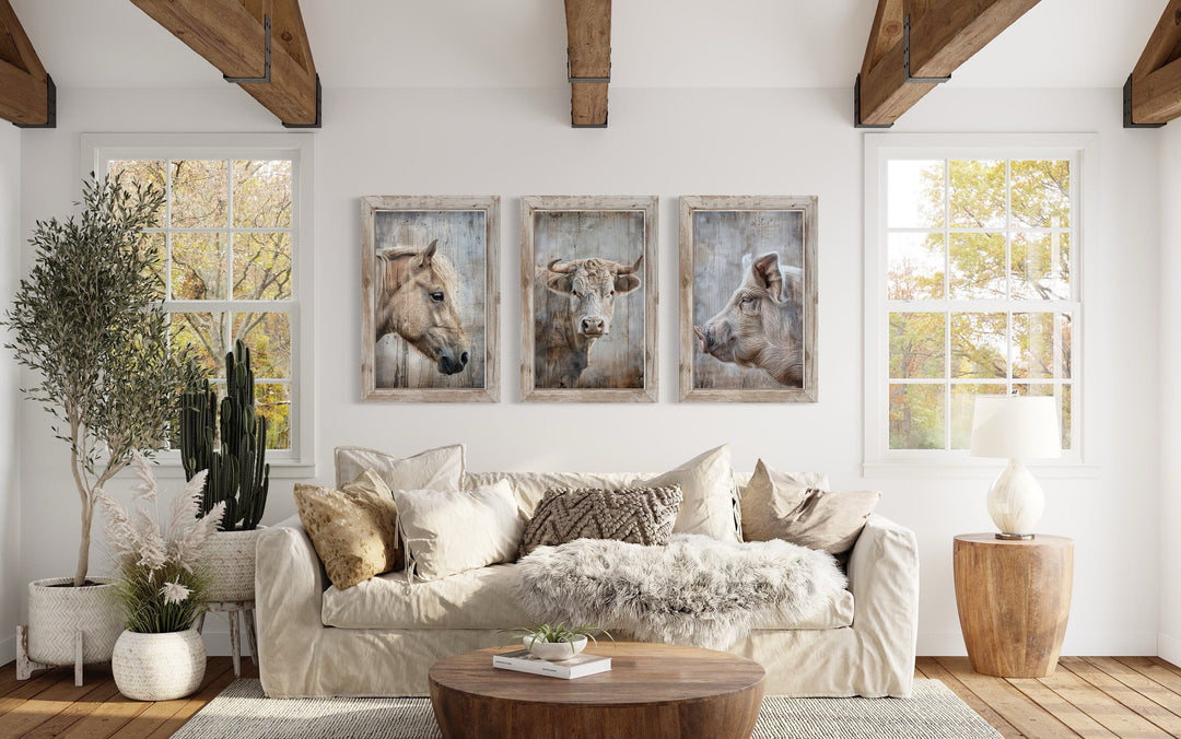 Set of 3 framed rustic farmhouse animal paintings featuring a horse, cow, and pig above a sofa.