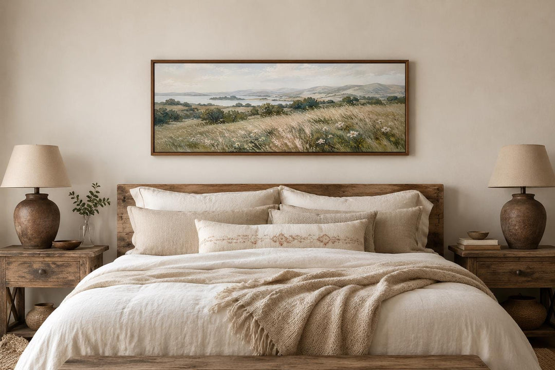 Long horizontal farmhouse wall art of a neutral grass field landscape above a bed.