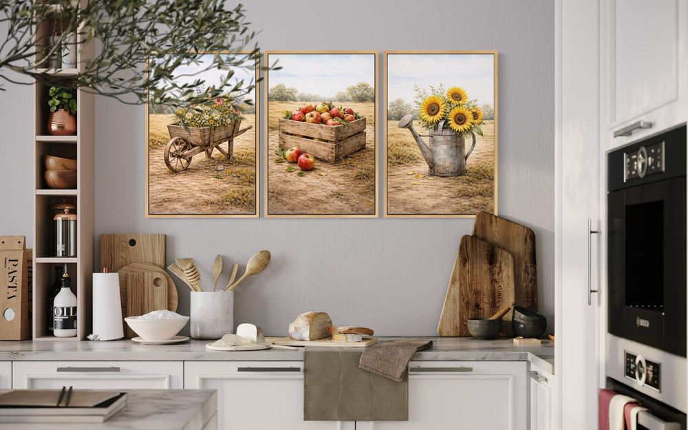 Set of three rustic farmhouse canvas prints featuring a wheelbarrow, apples, and sunflowers.