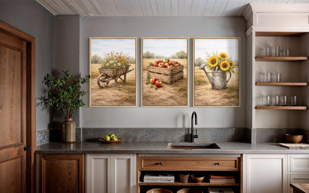 Set of three rustic farmhouse canvas prints featuring a wheelbarrow, apple crate, and watering can.