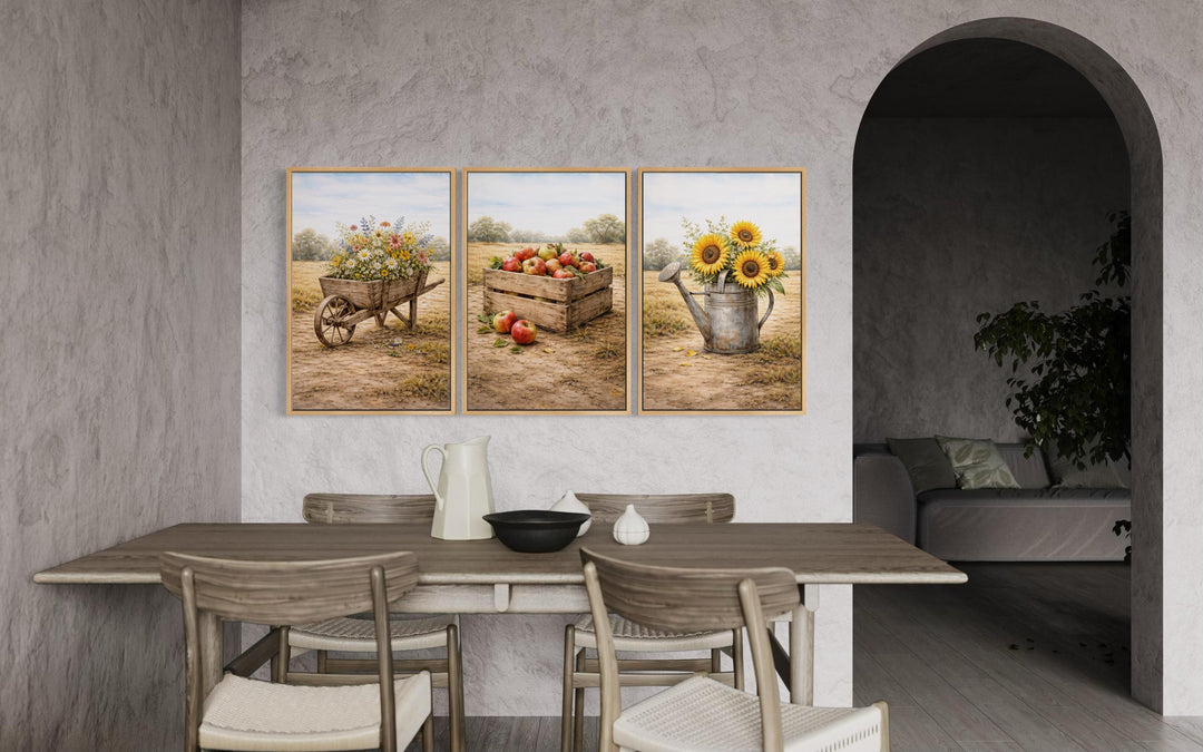 Set of three rustic farmhouse canvas prints featuring a wheelbarrow, apple crate, and watering can.