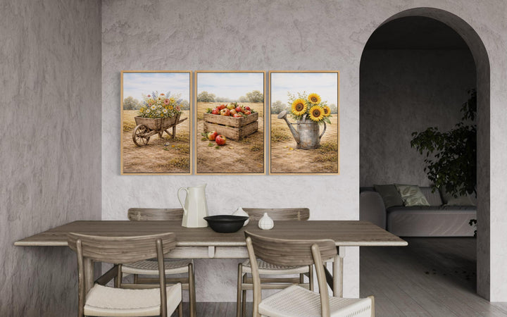 Set of three rustic farmhouse canvas prints featuring a wheelbarrow, apple crate, and watering can.
