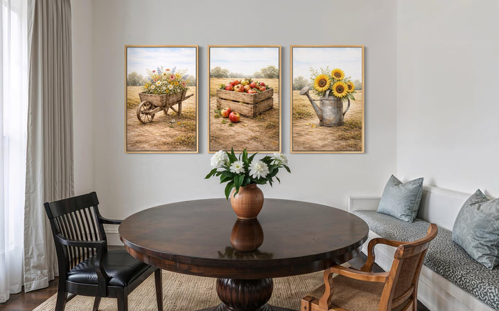 Set of three rustic farmhouse canvas prints featuring a wheelbarrow, apple crate, and watering can.