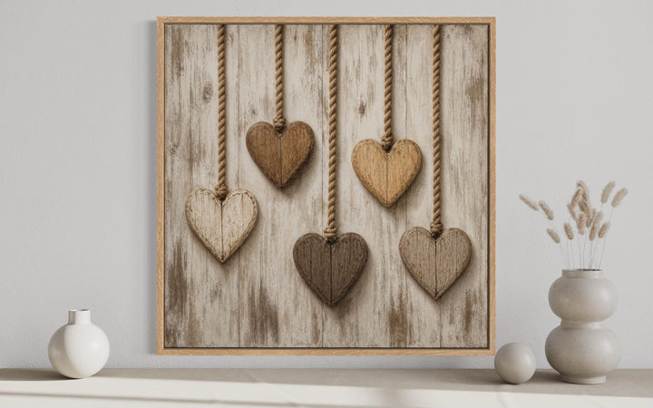 Rustic heart canvas wall art featuring five wooden hearts hanging against whitewashed wood planks.