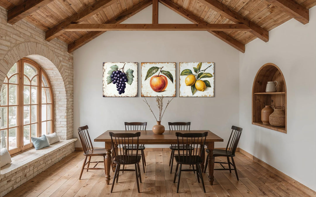 Vintage fruit canvas triptych featuring grapes, a peach, and lemons in a rustic dining room.