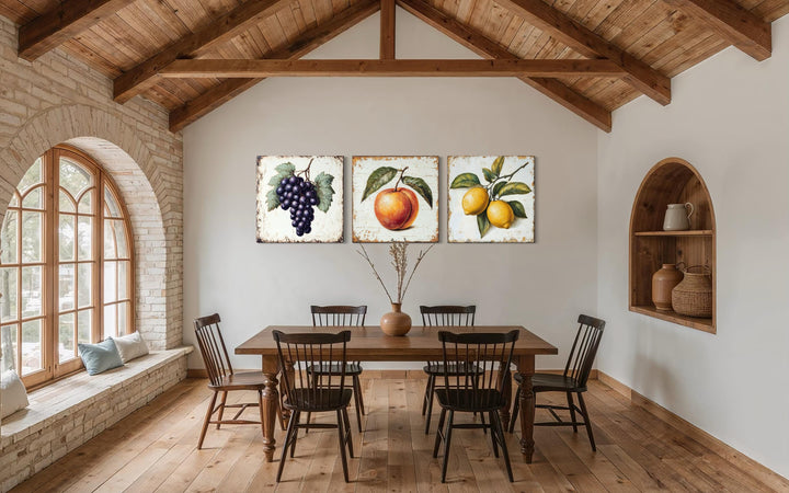 Vintage fruit canvas triptych featuring grapes, a peach, and lemons in a rustic dining room.