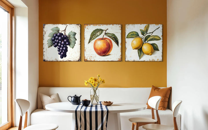 Vintage fruit canvas triptych featuring grapes, a peach, and lemons on a warm yellow wall.