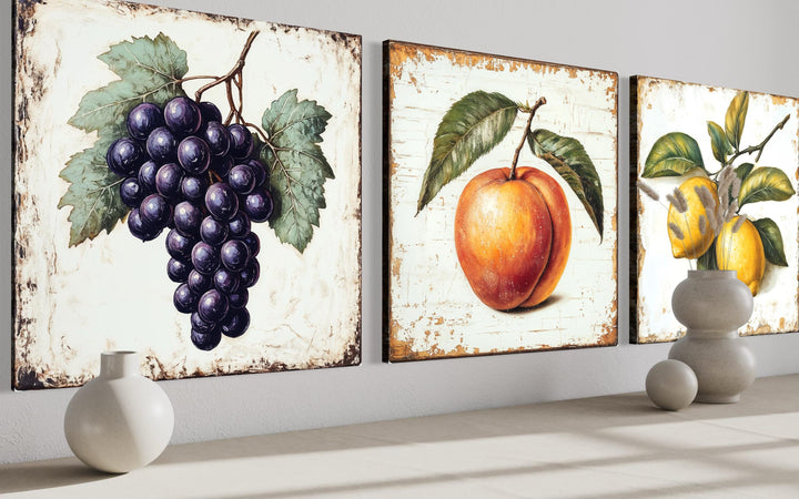 Set of three vintage botanical canvas prints featuring grapes, a peach, and lemons on aged backgrounds.