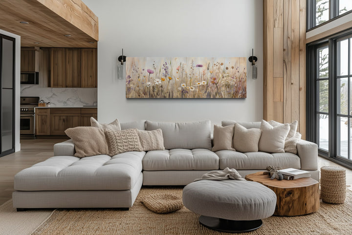 Farmhouse style neutral wildflowers field horizontal framed canvas wall art above a gray sofa.