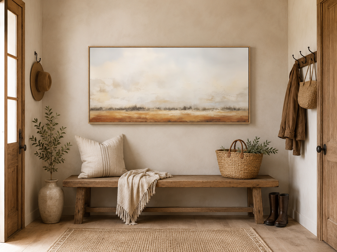 Minimalist farm field canvas art in a neutral rustic entryway above a wooden bench.