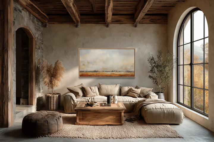 Minimalist farm field canvas art in a rustic living room with neutral tones and wooden beams.