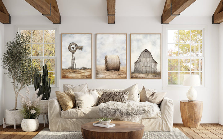Set of three rustic farmhouse prints featuring a windmill, hay bale, and barn above a beige sofa.
