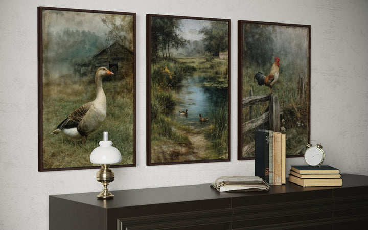 Three framed farmhouse paintings of a goose, ducks in a pond, and a rooster on a wooden dresser.