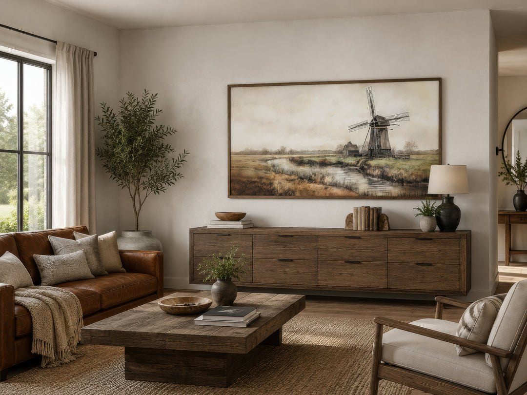 Vintage windmill wall art in a rustic frame above a wooden sideboard in a farmhouse living room.