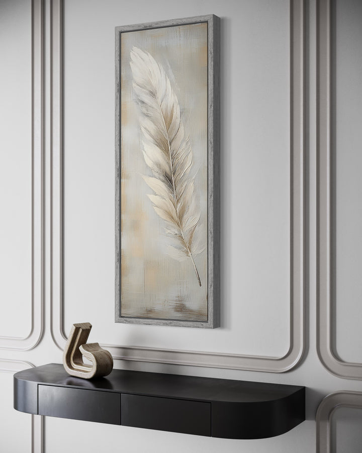 Tall vertical framed canvas wall art featuring a white feather on a rustic wood-textured background.