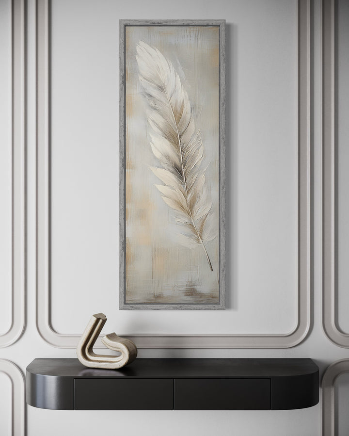 Tall vertical framed canvas wall art featuring a white feather on a rustic wood-textured background.