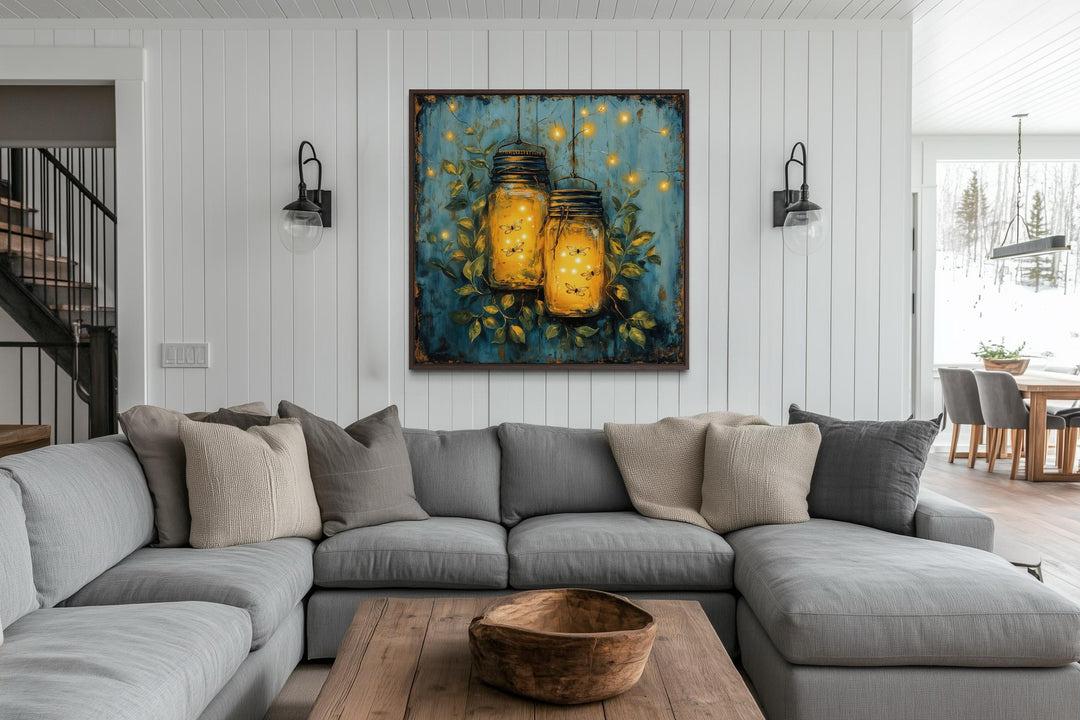 Framed canvas wall art of glowing fireflies in mason jars hanging in a modern farmhouse living room.