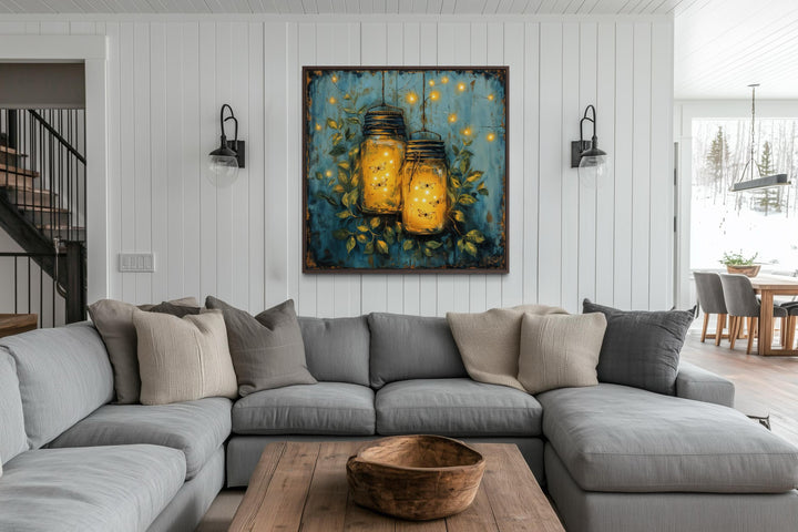 Framed canvas wall art of glowing fireflies in mason jars hanging in a modern farmhouse living room.