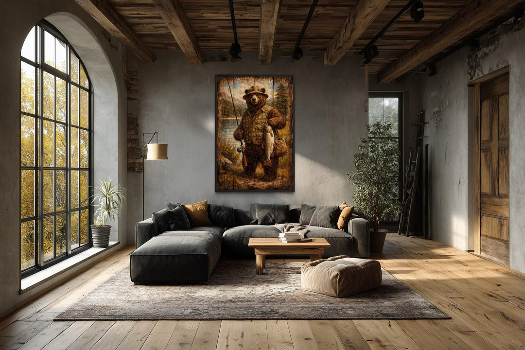 Rustic wall art of a brown bear dressed as a fisherman hanging in a modern lodge-style living room.