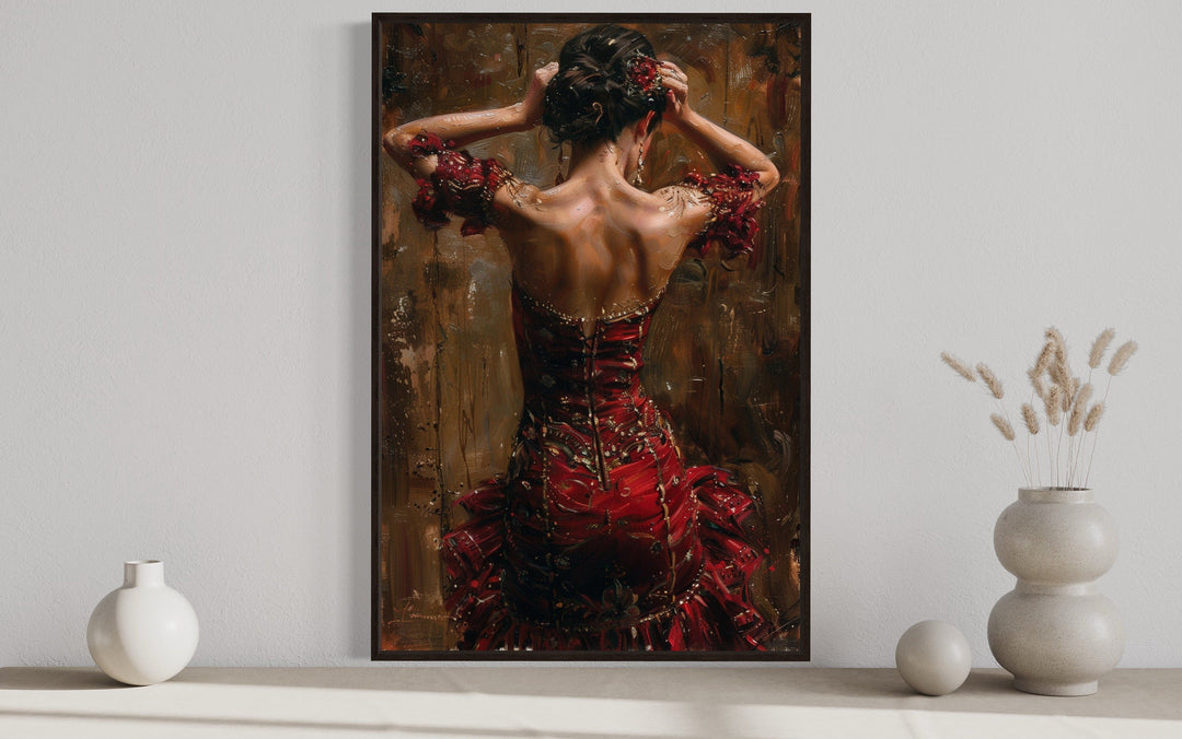 Framed canvas wall art of a flamenco dancer in a red dress, seen from behind with arms raised.