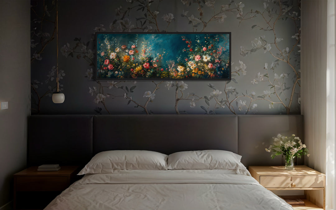 Long narrow canvas wall art of a floral garden on a teal background hanging above a bed.