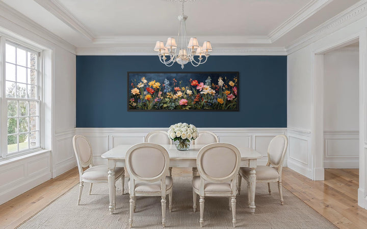 A long horizontal canvas print of colorful wildflowers on a navy background in a dining room.