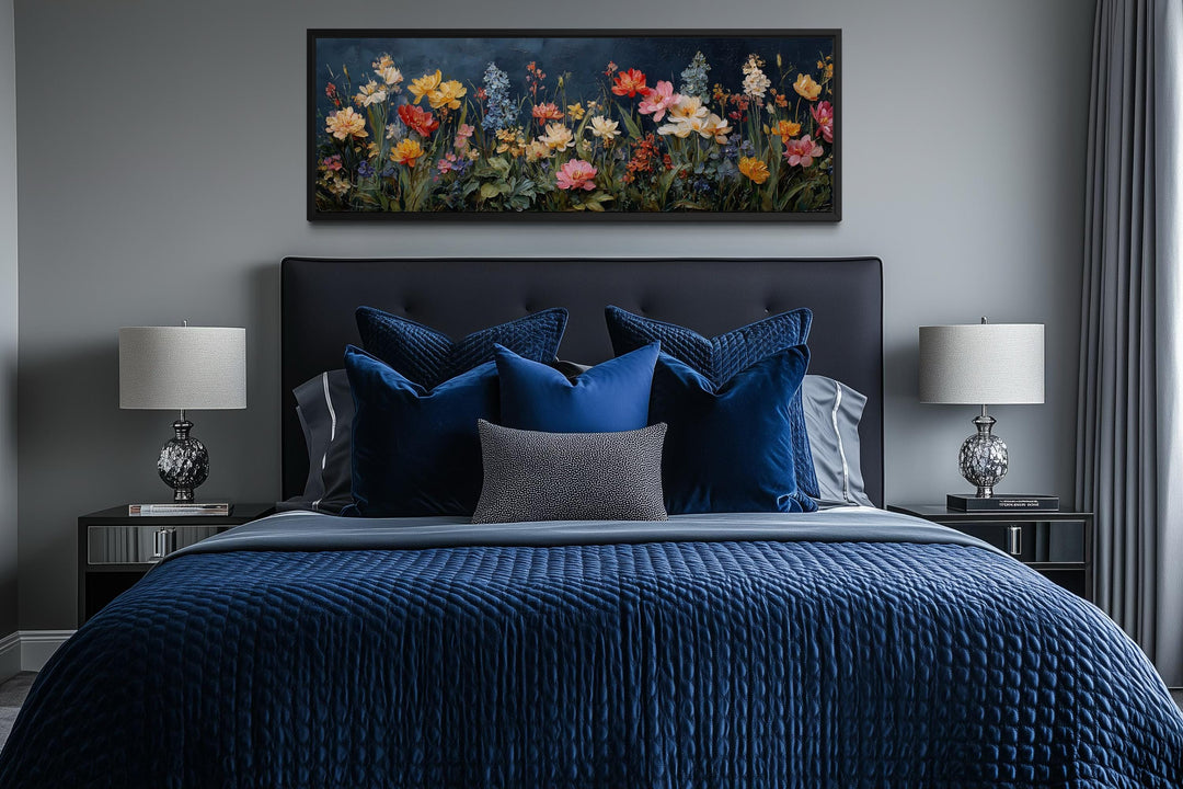 Long horizontal floral meadow wall art with wildflowers on a navy background above a bed.