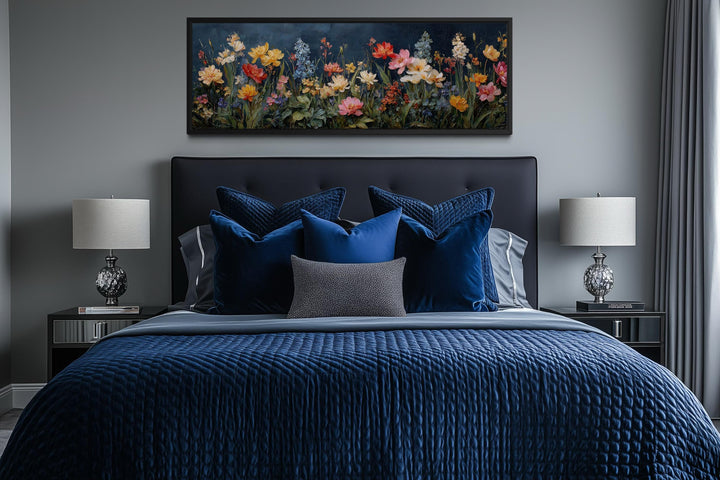 Long horizontal floral meadow wall art with wildflowers on a navy background above a bed.