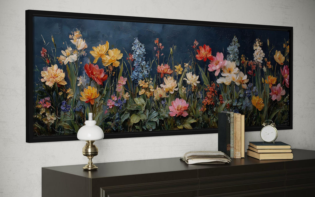 A long horizontal canvas print of colorful wildflowers against a dark navy background in a black frame.
