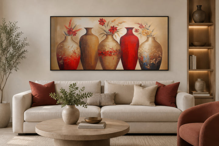 Horizontal canvas wall art featuring five elegant red and gold floral vases above a modern sofa.