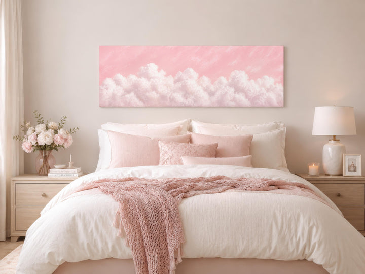 Long horizontal canvas print of fluffy white clouds on a blush pink sky above a cozy pink bedroom.