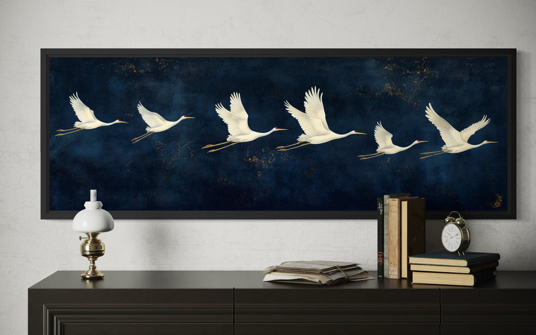 Panoramic wall art featuring white cranes flying across a deep navy blue background.