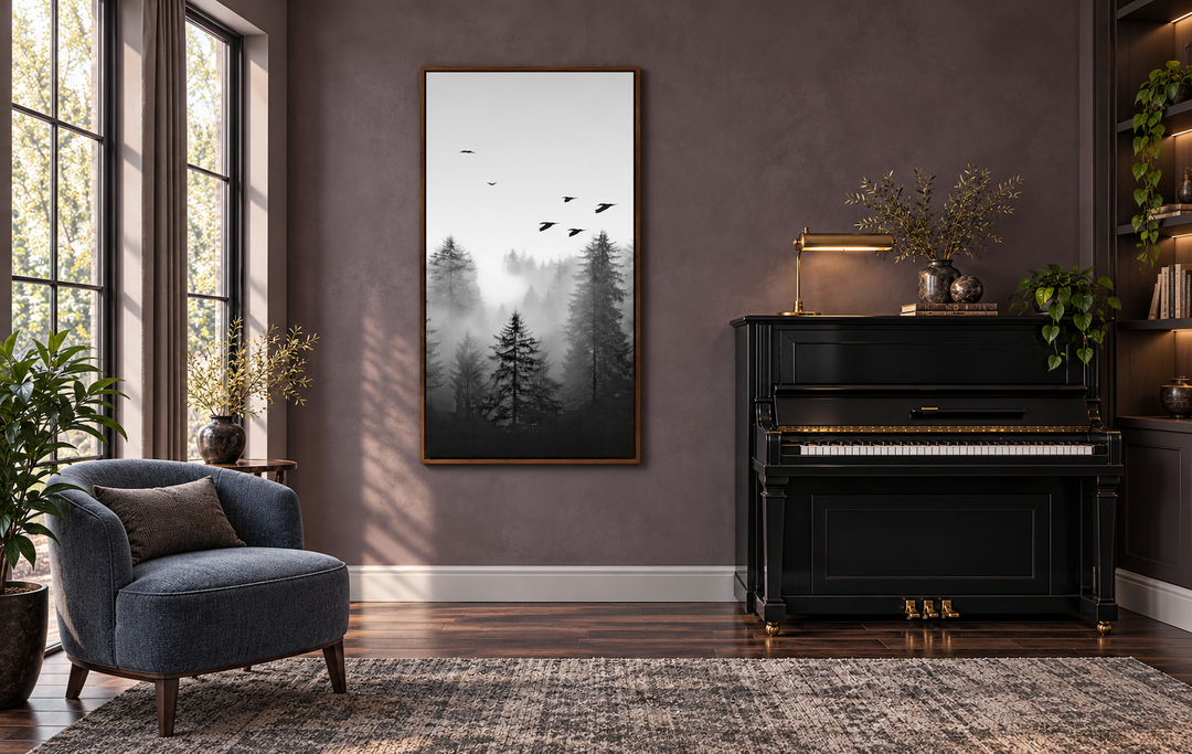 Tall vertical black and white canvas art of a foggy fir forest with birds, framed on a plum wall.