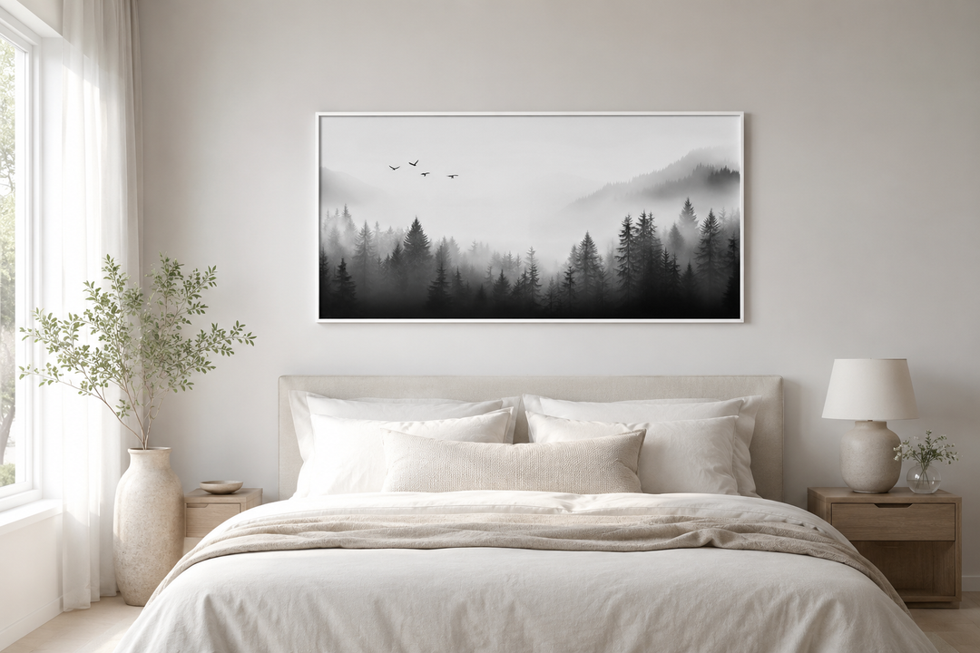 Foggy forest black and white minimalist framed canvas wall art hanging above a bed.