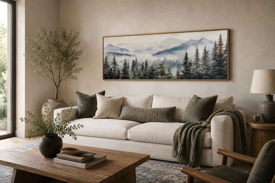 Foggy forest sage green long horizontal wall art in a wood frame above a white sofa.