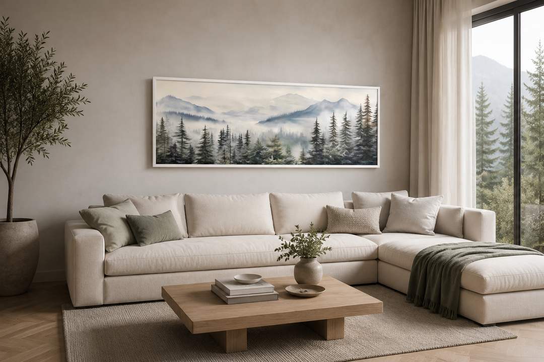 Foggy forest sage green long horizontal wall art in a white frame above a cream sectional sofa.