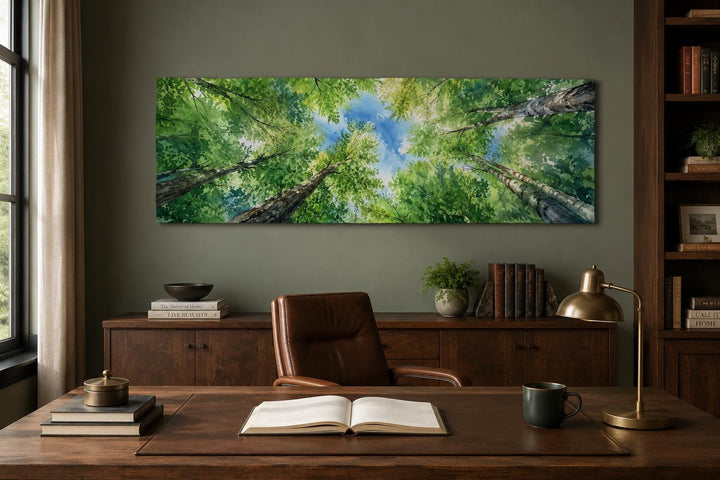 Wide forest canopy wall art showing an upward view of green trees and blue sky in a home office.