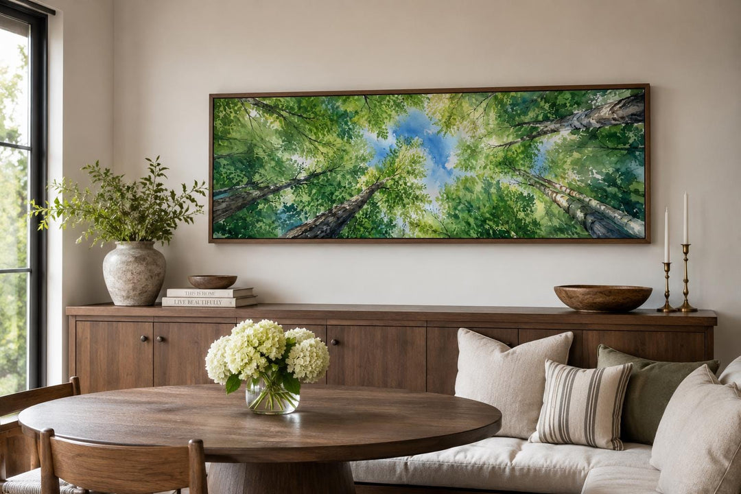 Horizontal forest canopy wall art with green trees and blue sky over a modern farmhouse sideboard.