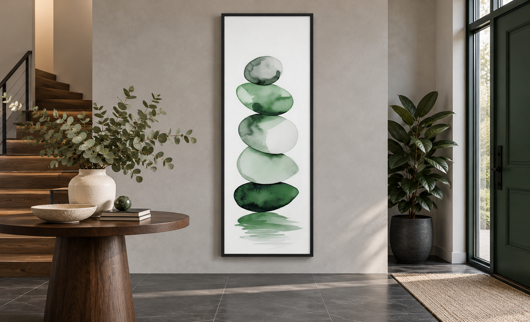 Tall narrow vertical framed canvas art of stacked forest green watercolor rocks in a modern foyer.