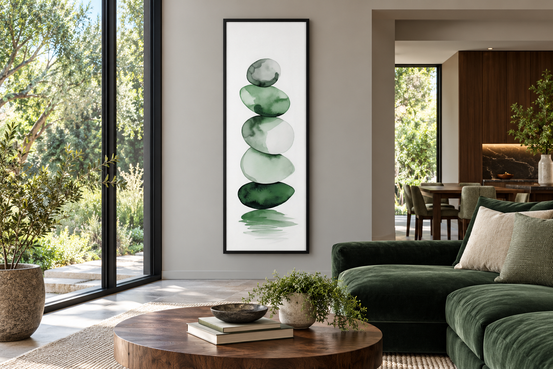 Tall narrow framed canvas art of stacked forest green watercolor rocks in a modern living room.