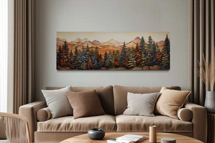 Panoramic forest and mountain landscape canvas art hanging above a tan sofa in a modern room.