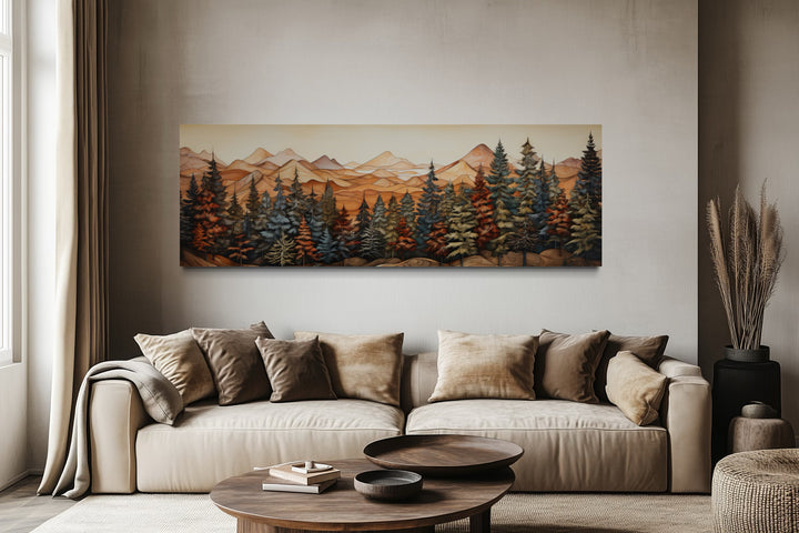 Long horizontal canvas art of a forest and mountains above a beige sofa in a rustic living room.
